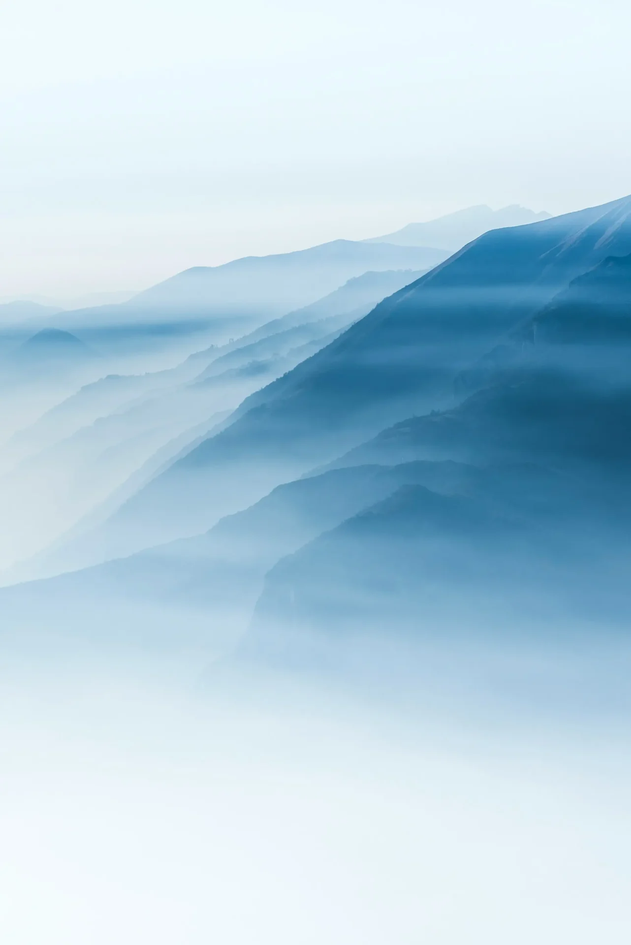 alessio-soggetti-cfKC0UOZHJo-unsplash Layered blue mountain landscape in soft light.