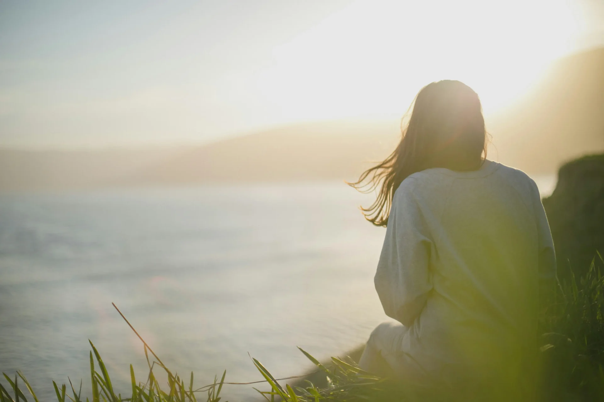 artem-kovalev-fk3XUcfTAvk-unsplash (1) Woman sitting peacefully beside the sea