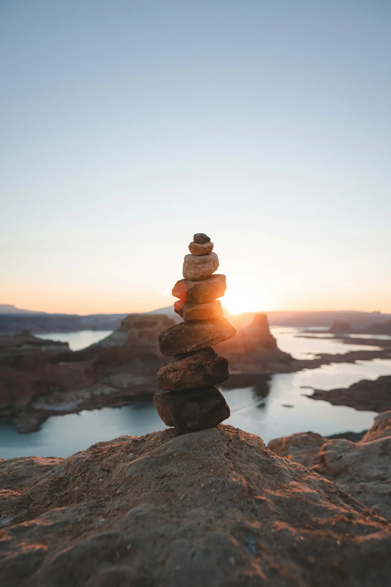 trey-k-LLbr6-5-vgQ-unsplash Balanced stones on a beach at sunset.